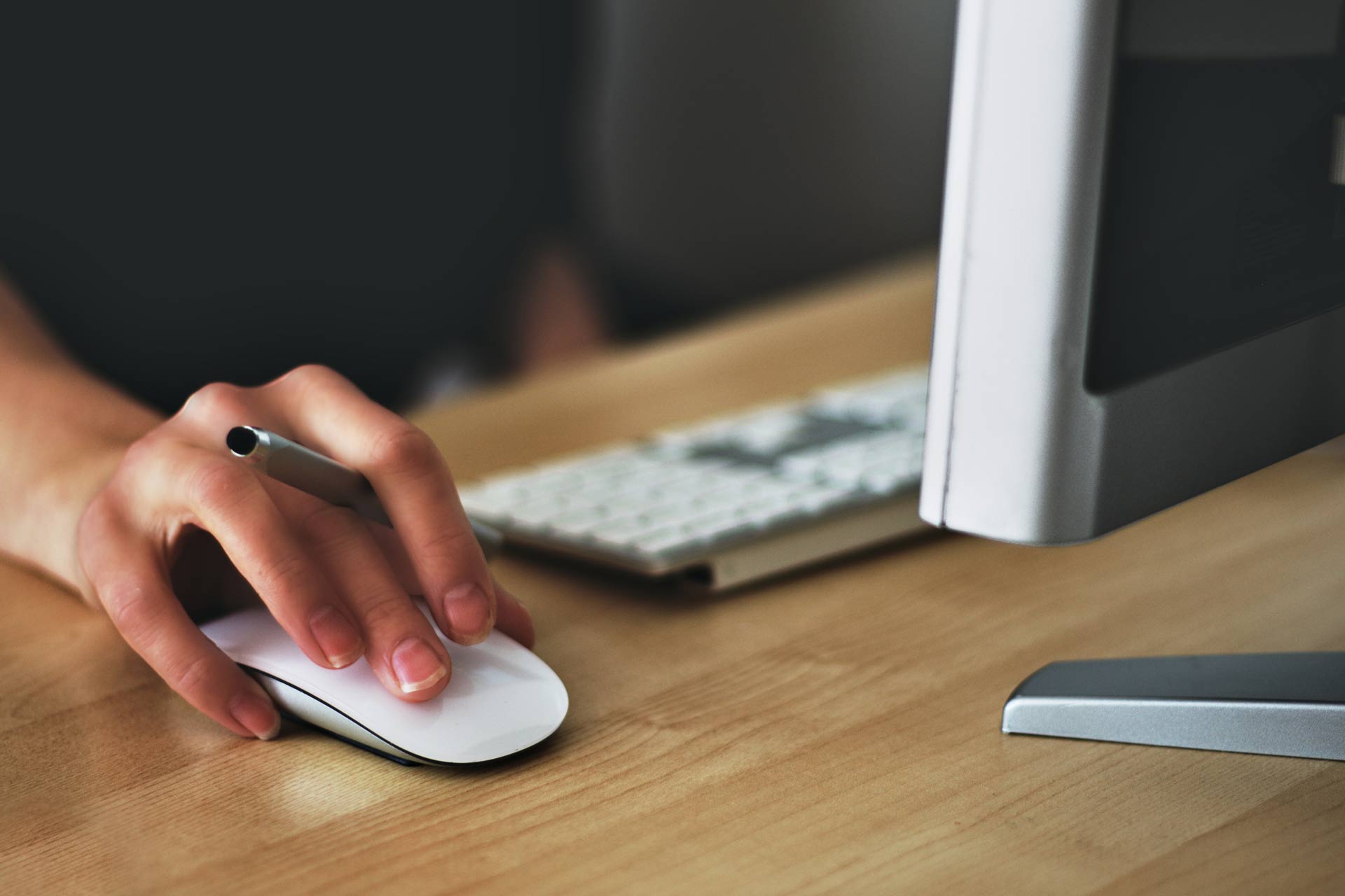 woman handling a mouse at a desktop computer