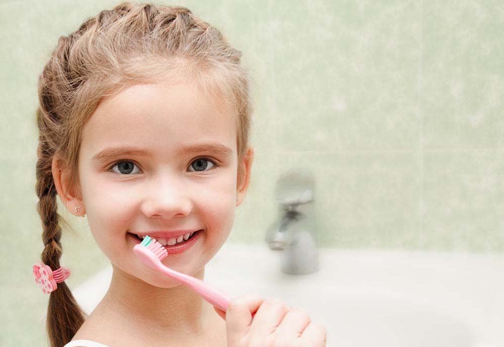 girl with tooth brush near mouth