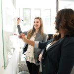 2 business women at a white board