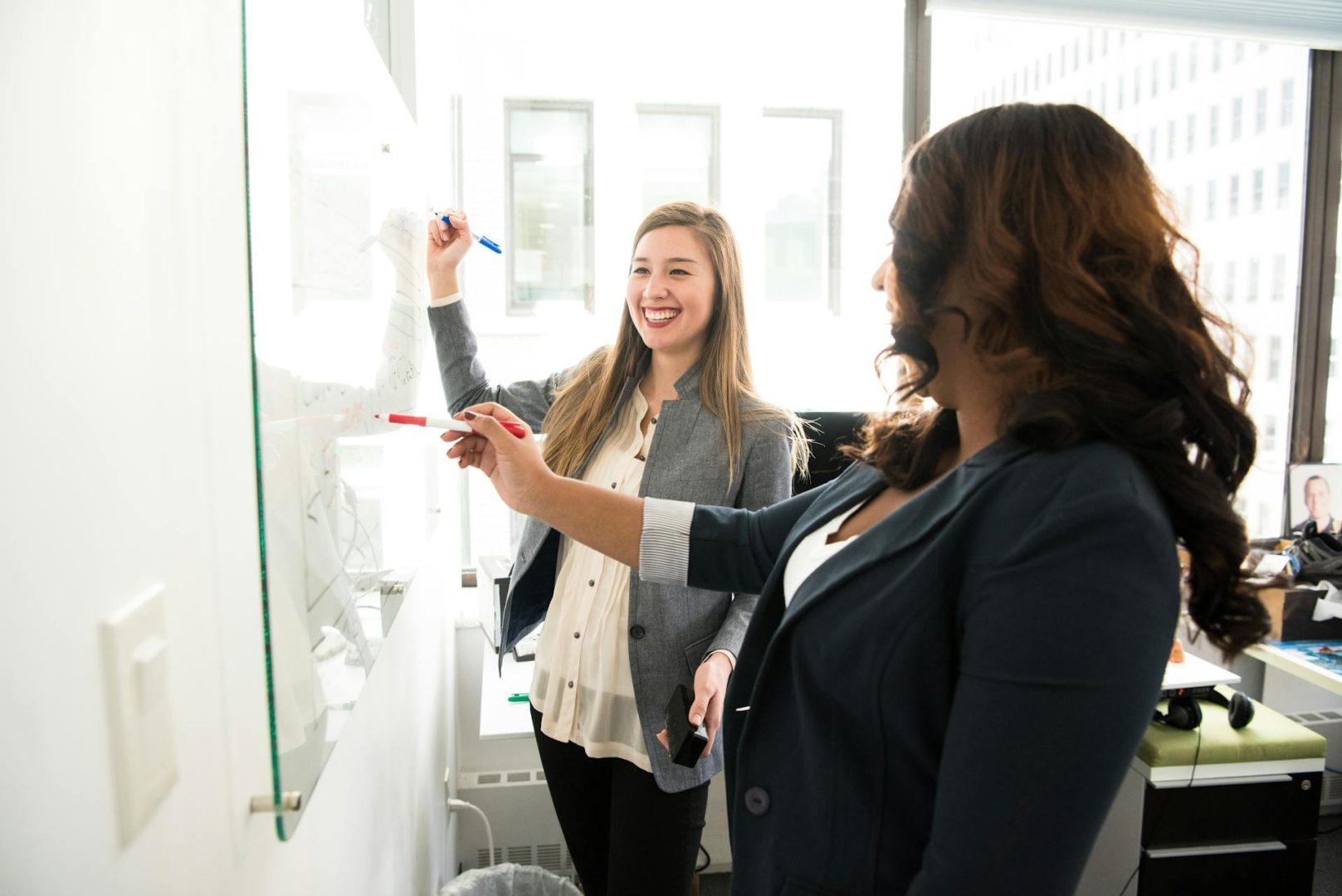 2 business women at a white board