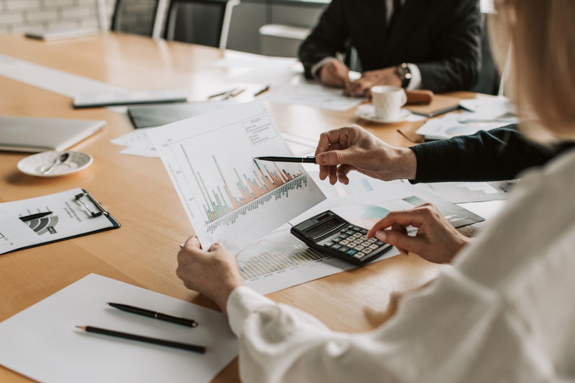 Two professional women looking at a piece of paper with a financial chart